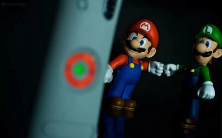 A vibrant HD PC desktop wallpaper featuring Mario and Luigi figures playfully interacting near an Xbox controller, capturing the essence of video game culture.