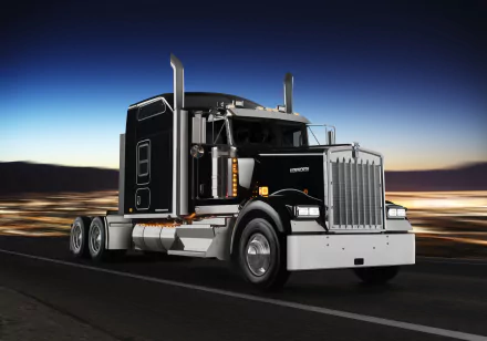 8K Ultra HD wallpaper of a black Kenworth W900 truck driving on a highway at dusk, showcasing the vehicle's distinctive front grille and classic design.