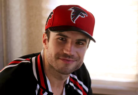 HD desktop wallpaper background featuring a man in a Falcons cap smiling at the camera.