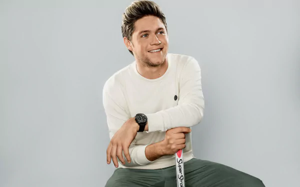 HD wallpaper featuring Niall Horan, smiling and dressed casually, creating a vibrant and inviting background for music lovers.