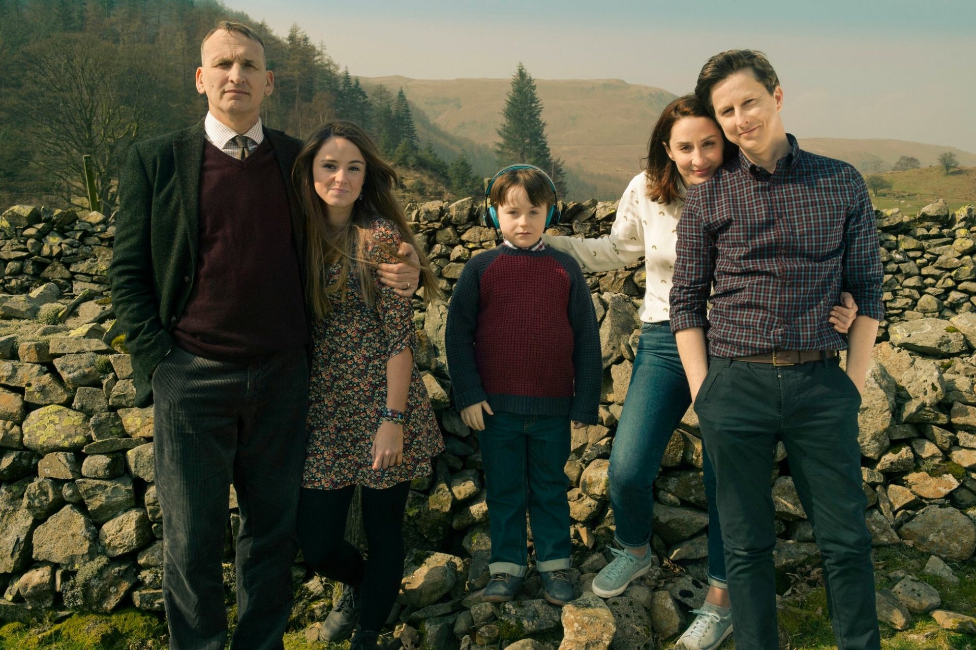 HD desktop wallpaper featuring the cast of The A Word standing by a stone wall in a rural setting.