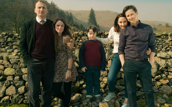 HD desktop wallpaper featuring the cast of The A Word standing by a stone wall in a rural setting.