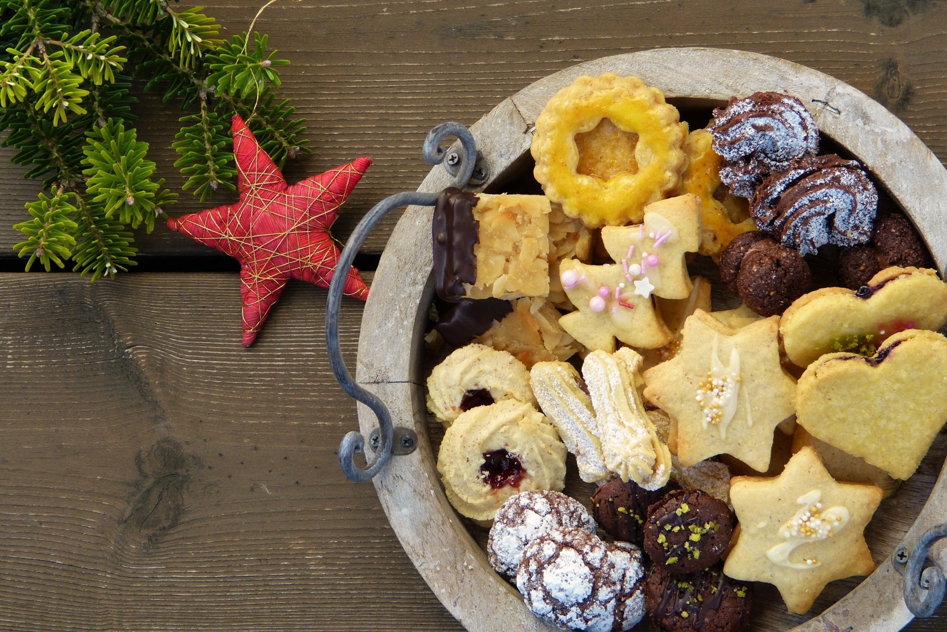 A variety of festive cookies arranged in a bowl on a wooden table, with holiday-themed decorations, captured in crisp 4K Ultra HD for PC desktop wallpaper use.