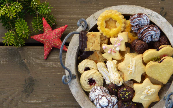 A variety of festive cookies arranged in a bowl on a wooden table, with holiday-themed decorations, captured in crisp 4K Ultra HD for PC desktop wallpaper use.