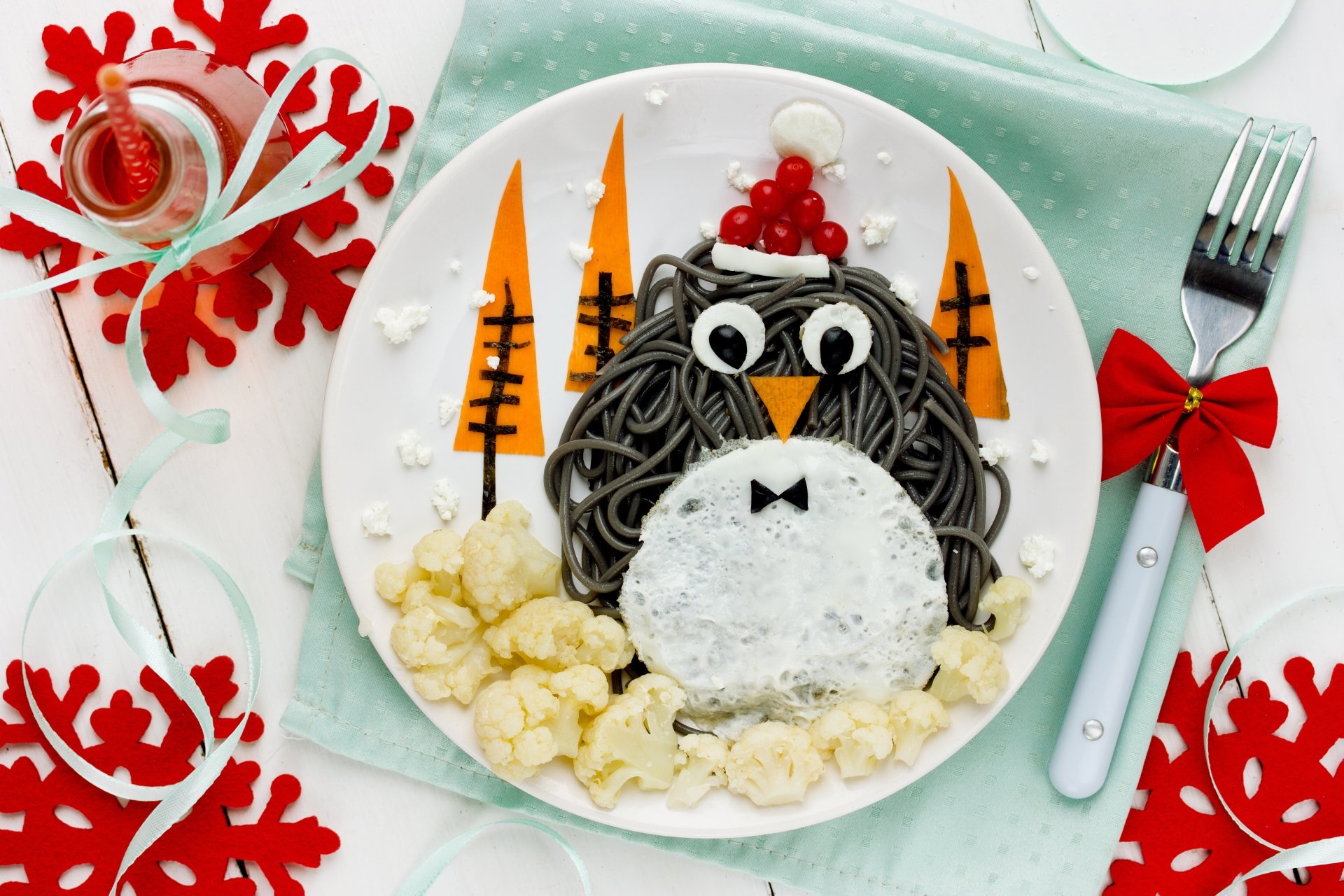 4K Ultra HD desktop wallpaper showing a creative penguin meal made with black pasta, rice, popcorn, and red berries on a festive plate setting.