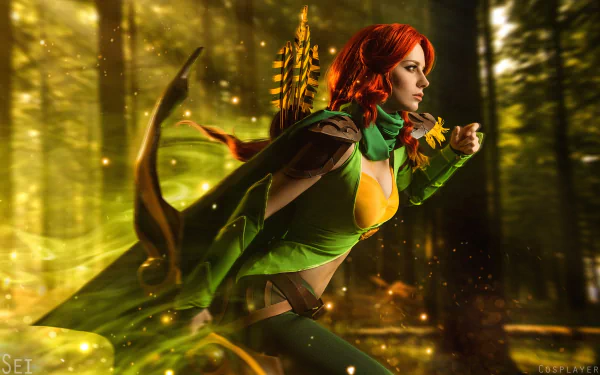 HD PC desktop wallpaper featuring a woman cosplaying Windranger from DotA 2 in a dynamic forest setting with glowing light effects.