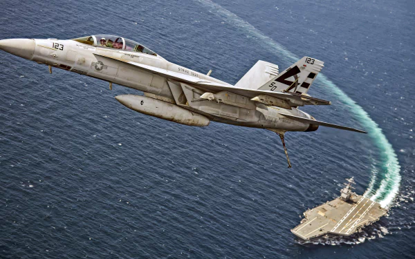 A Boeing F/A-18E/F Super Hornet jet fighter flies above a warship aircraft carrier over the ocean, captured in stunning 4K Ultra HD detail.