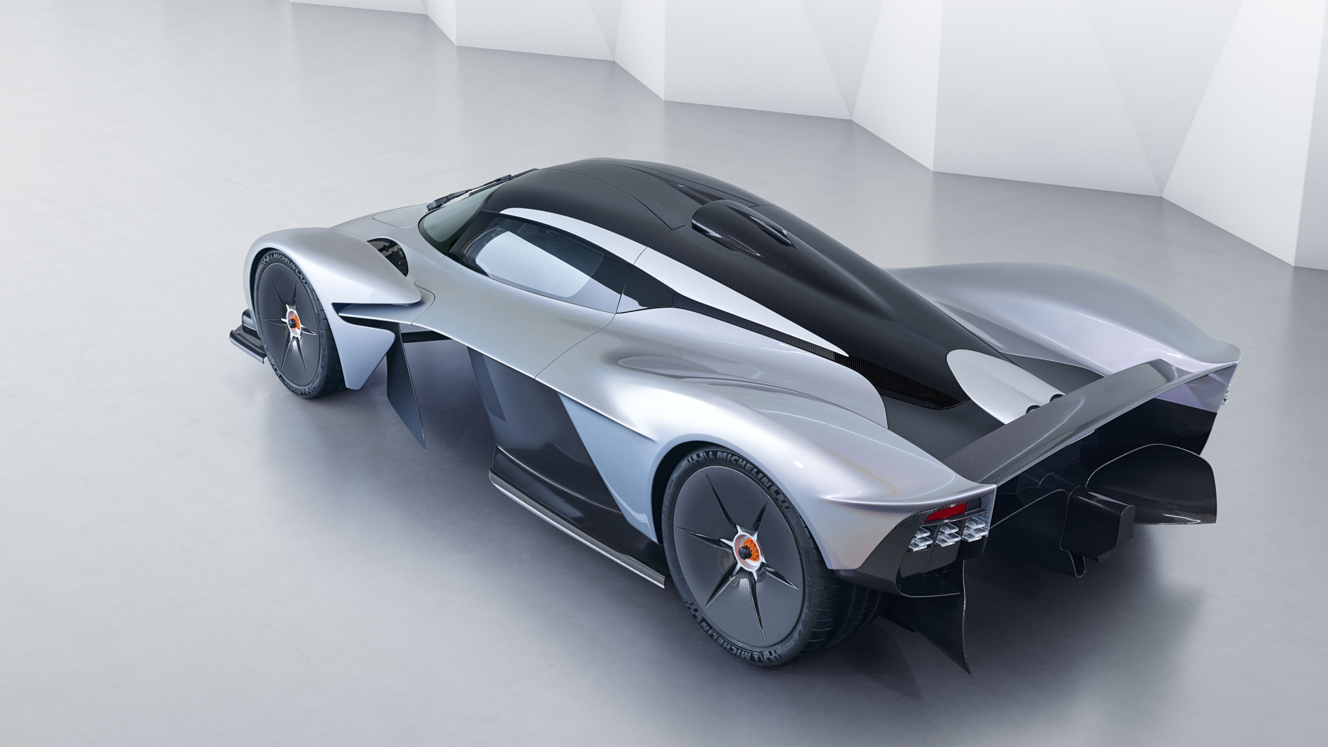 Sleek Aston Martin Valkyrie hybrid supercar in a minimalist white space, showcased as a high-definition PC desktop wallpaper and background.