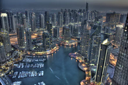 A stunning cityscape of Dubai at night, showcasing vibrant skyscrapers and a serene harbor filled with boats, captured in 4K Ultra HD resolution.