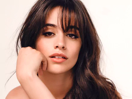 Close-up HD portrait of Camila Cabello, American Latina singer with brunette hair and brown eyes, set against a plain background.
