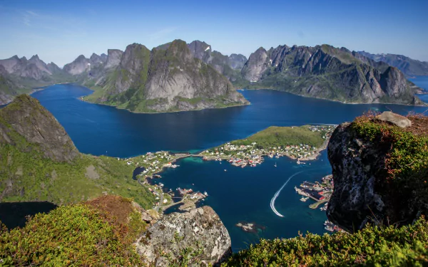 A stunning HD desktop wallpaper showcasing Reine village nestled by a lake and rugged mountains in Lofoten, Norway, featuring vivid natural beauty and serene waters.