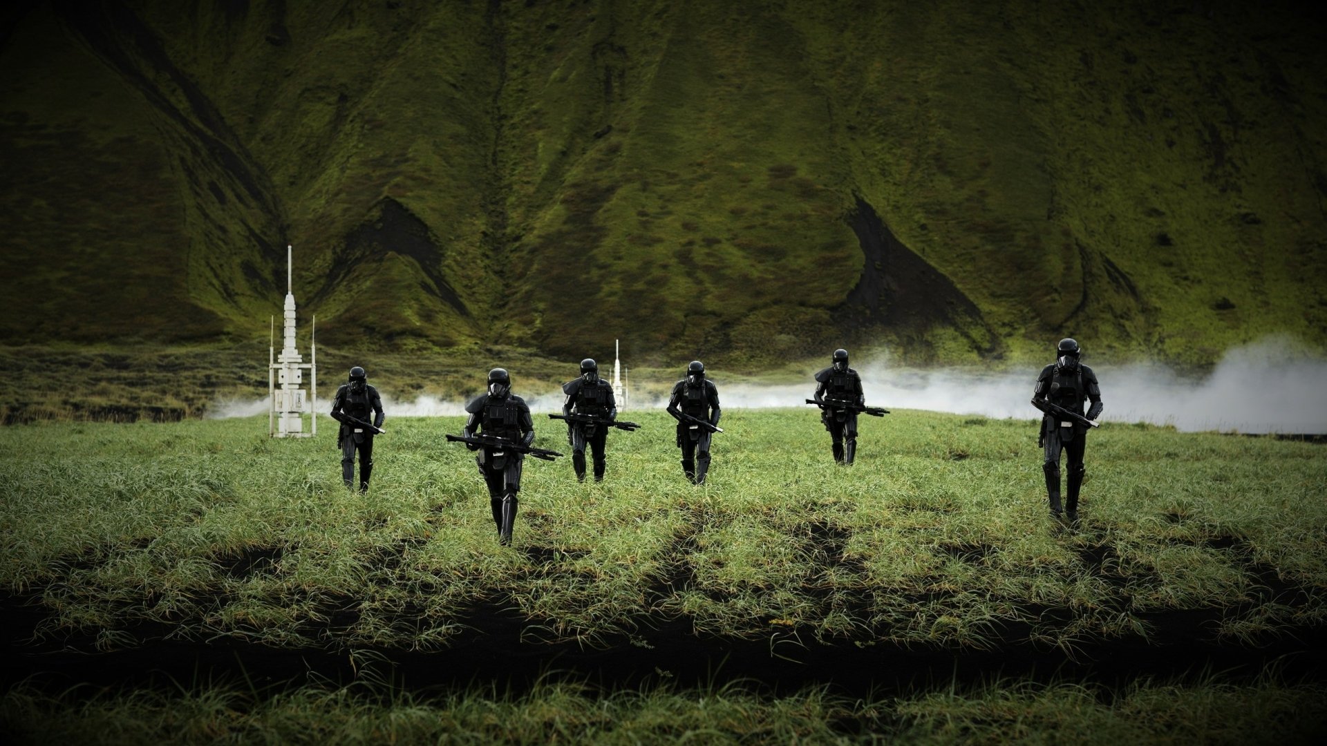 HD PC desktop wallpaper featuring Death Troopers from Rogue One: A Star Wars Story advancing across a grassy field with a misty, mountainous background.