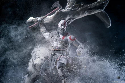 HD desktop wallpaper featuring a figurine of Kratos from God of War (2018), mid-battle amidst a dynamic, dust-filled backdrop.