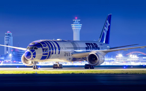 HD desktop wallpaper of a Boeing 787 Dreamliner at an airport, illuminated at night with control towers in the background.