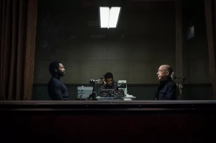 HD desktop wallpaper from the show Counterpart featuring three characters engaging in a tense conversation in a dimly lit room.