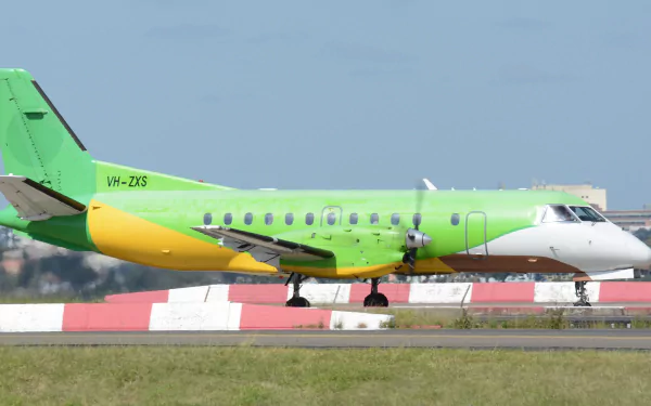 Bright green-and-yellow Saab 340B passenger aircraft vehicle taxiing on a runway; 2K Quad HD PC desktop wallpaper/background.