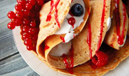 2K Quad HD PC desktop wallpaper: close-up of crêpes filled with cream and berries, drizzled with red sauce on a plate — food crêpe background.