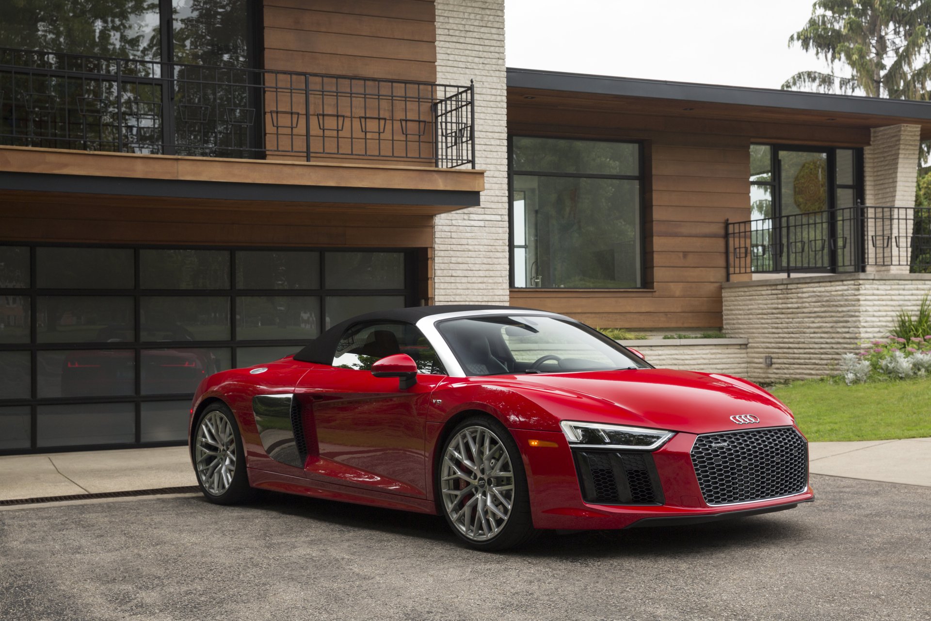 Red Audi R8 supercar parked in front of a modern house — 2K Quad HD PC desktop wallpaper and background featuring a sleek Audi sports car.