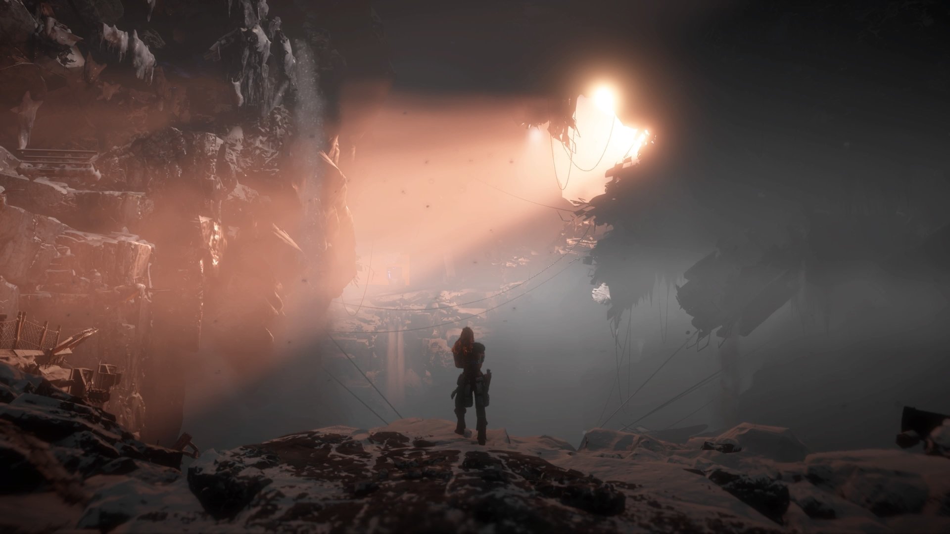 A lone figure stands on rocky terrain illuminated by a glowing mechanical creature in a dark, misty environment from Horizon Zero Dawn, captured in 4K Ultra HD.