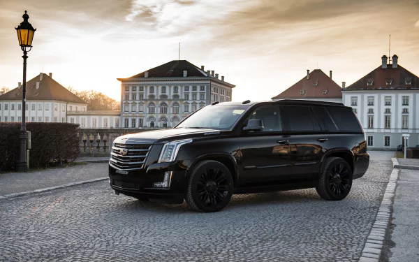 Black Cadillac Escalade SUV parked on a cobblestone street with historic buildings in the background, captured in 4K Ultra HD for a PC desktop wallpaper.