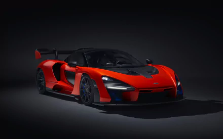 HD wallpaper of a stunning red McLaren Senna supercar showcased against a dark background.