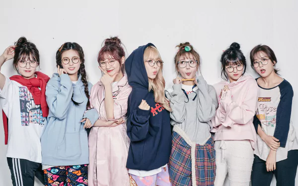 HD desktop wallpaper of seven smiling women in glasses with blonde and brunette hair, posing together in a colorful TV-show vibe inspired by Idol Drama Operation Team.