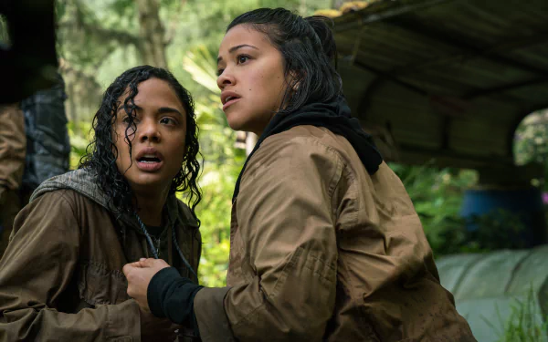 HD desktop wallpaper featuring Tessa Thompson and Gina Rodriguez in a scene from the film Annihilation, expressing intense emotions in a forest setting.