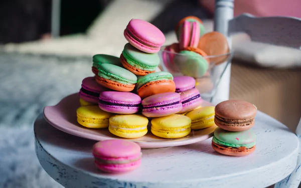 A colorful assortment of macarons arranged on a plate, showcasing vibrant sweets in a high-resolution 4K Ultra HD food-themed wallpaper.