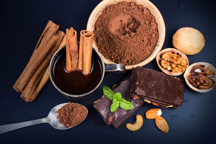 HD desktop wallpaper of a still life with chocolate, cinnamon sticks, cocoa powder, nuts, and a chocolate drink arranged on a dark background.