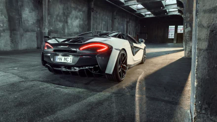 White McLaren 570S supercar parked inside an industrial building, captured in high-resolution 4K Ultra HD for a striking PC desktop wallpaper.