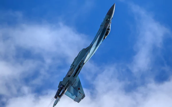A Sukhoi Su-35 military jet fighter soars vertically against a bright blue sky with scattered clouds in this HD warplane desktop wallpaper.