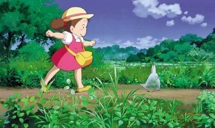 An HD desktop wallpaper featuring Mei Kusakabe and Mini Totoro from the anime My Neighbor Totoro. Mei is happily running through a lush green field, with Mini Totoro nearby under a vibrant sky.