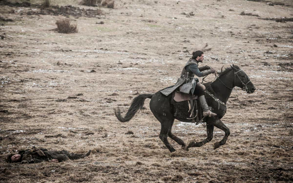 4K Ultra HD PC wallpaper: a cloaked warrior from the TV show Game of Thrones gallops a black horse across a windswept, snow-dusted field.