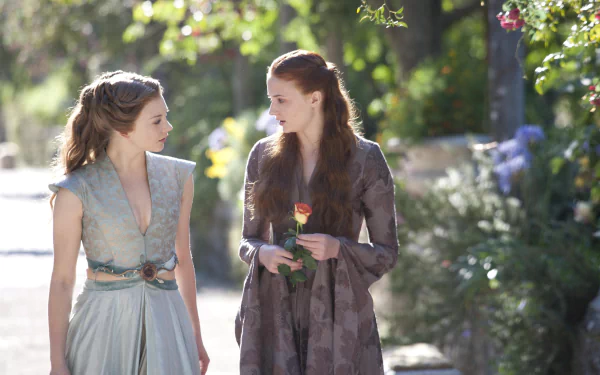 HD desktop wallpaper featuring Sophie Turner as Sansa Stark and Natalie Dormer as Margaery Tyrell from the TV show Game of Thrones, walking in a sunlit garden.