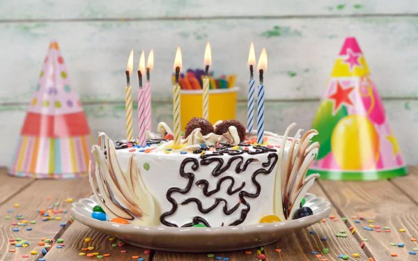4K Ultra HD image of a birthday cake with lit candles surrounded by colorful party hats, sprinkles, and festive decorations on a wooden table for a holiday celebration.