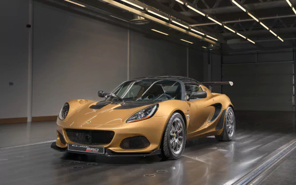 Gold Lotus Elise supercar parked in a glossy industrial garage, 4K Ultra HD PC desktop wallpaper of a Lotus (Car) sports vehicle.