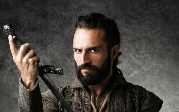 HD desktop wallpaper of a bearded character from Deus Salve o Rei, holding a sword, set against a textured grey background.