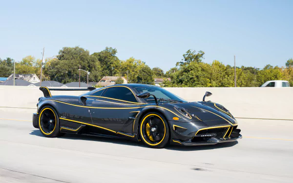 A sleek black Pagani Huayra Roadster BC supercar with yellow accents, captured in 4K Ultra HD as a striking PC desktop wallpaper and background.