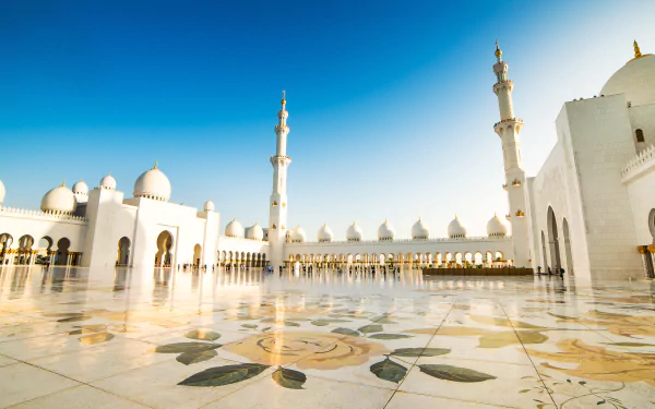 Religious 4K Ultra HD PC desktop wallpaper and background: Sheikh Zayed Grand Mosque courtyard with ornate marble floral inlay, white domes and minarets beneath a clear blue sky.