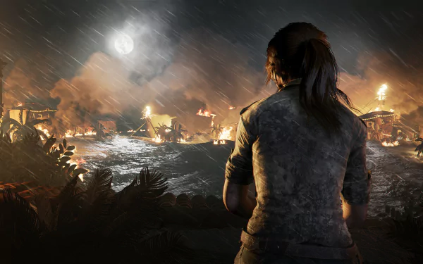 Lara Croft stands overlooking a burning village at night in this HD PC desktop wallpaper from the video game Shadow of the Tomb Raider.