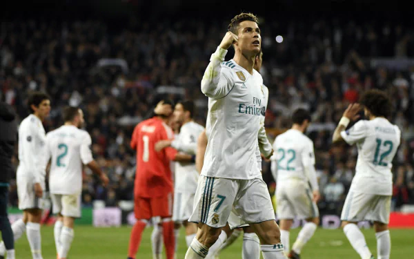 HD wallpaper featuring Cristiano Ronaldo in a soccer match, confidently celebrating a goal with teammates in the background. The image captures the excitement of Portuguese sports.