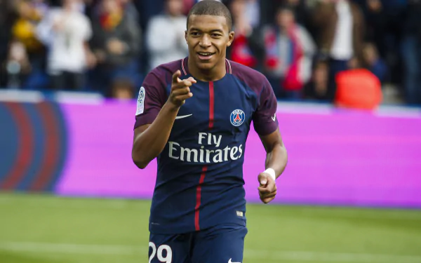 Kylian Mbappé, French soccer star, celebrates on the field in his PSG uniform, captured in a vibrant 4K Ultra HD sports wallpaper background.