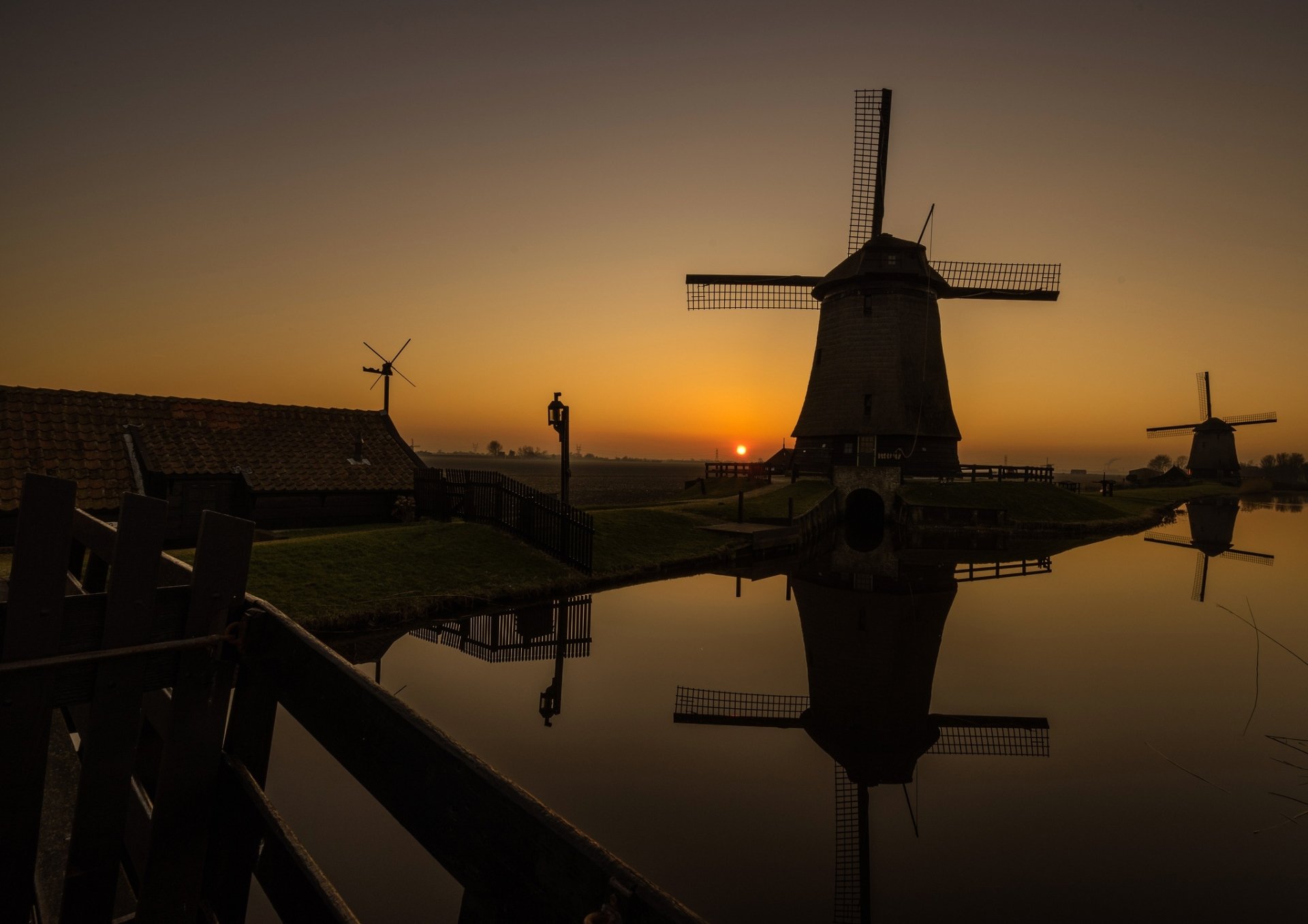 HD desktop wallpaper featuring a night scene with windmills reflected in the water, creating a tranquil atmosphere against a dusky sky.