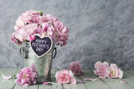 A 4K Ultra HD still life of pink flowers arranged in a metal bucket with a Happy Mother's Day tag, set against a gray textured background.