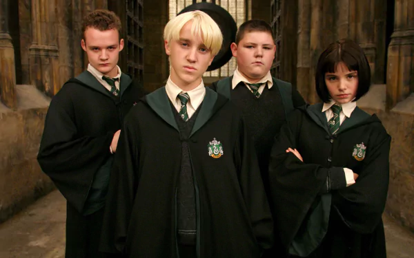HD desktop wallpaper featuring Tom Felton as Draco Malfoy with fellow Slytherin students from the Harry Potter movie series, set in a Hogwarts corridor.