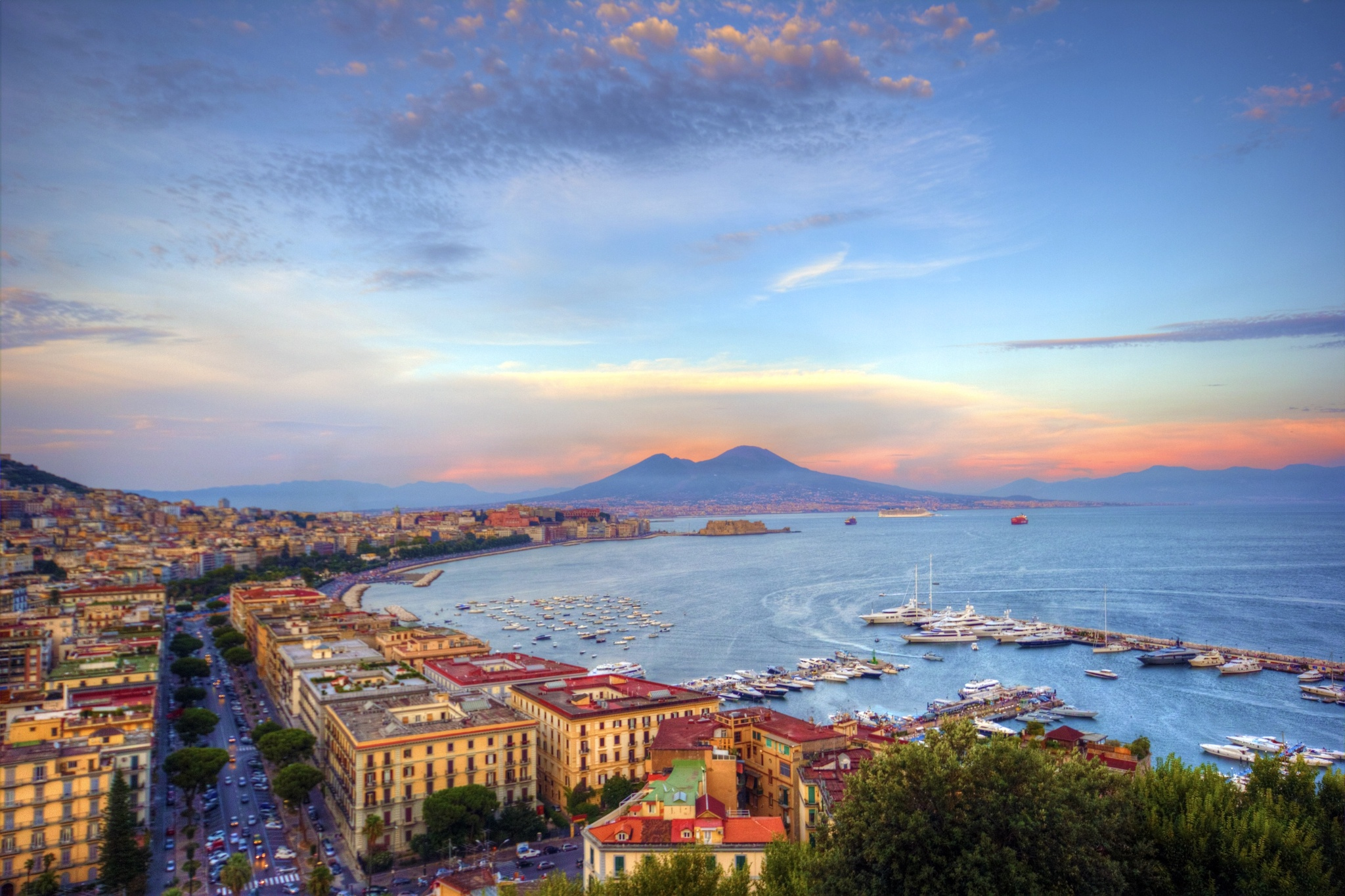Boat cruising along the coast of Naples, Italy, showcasing the charming cityscape against a stunning HD desktop wallpaper backdrop.