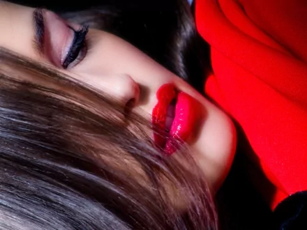 Close-up of a woman's face with sensual lips, featuring striking red lipstick and soft waves of hair. An HD desktop wallpaper showcasing beauty and elegance.