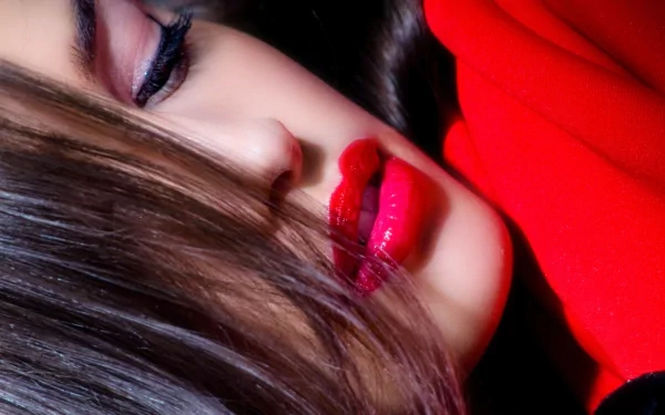 Close-up of a woman's face with sensual lips, featuring striking red lipstick and soft waves of hair. An HD desktop wallpaper showcasing beauty and elegance.