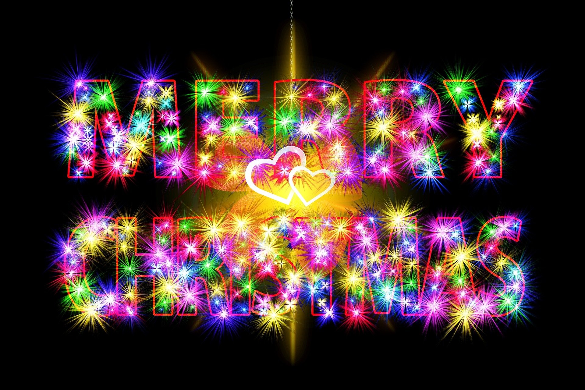 Vibrant, colorful Merry Christmas text with sparkling lights on a dark background, designed as a festive HD PC desktop wallpaper celebrating the holiday season.