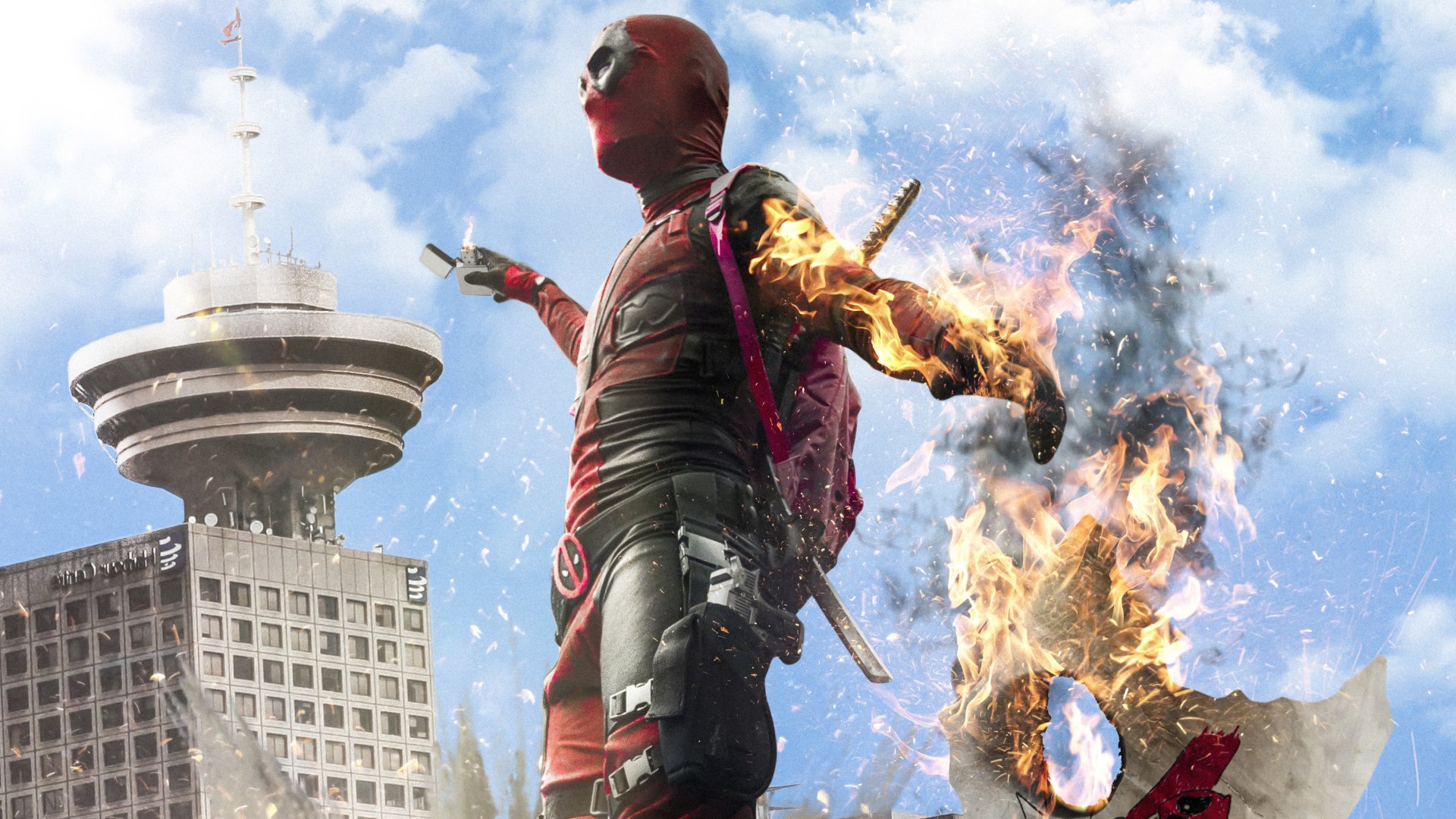 Deadpool from the movie Deadpool 2 in a fiery action pose against an urban explosion — 2K Quad HD PC desktop wallpaper and background.